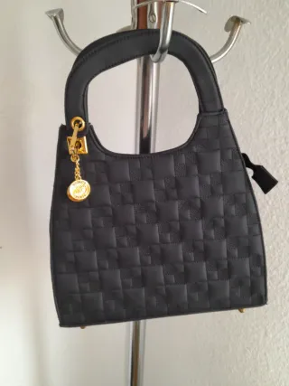 Bolso negro acolchado con charm dorado