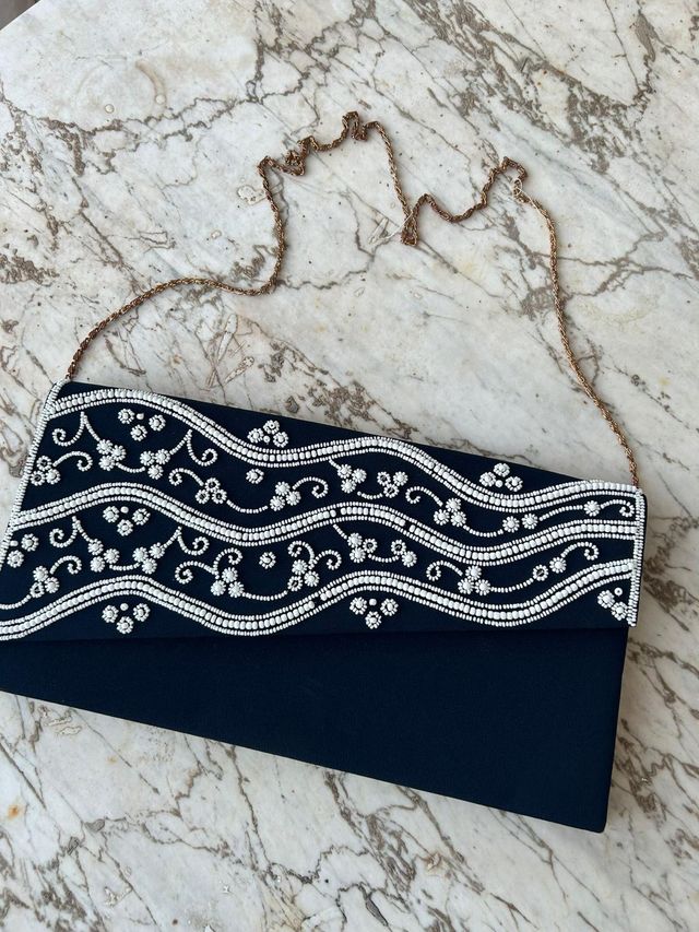 Bolso de mano negro con pedrería y cadena