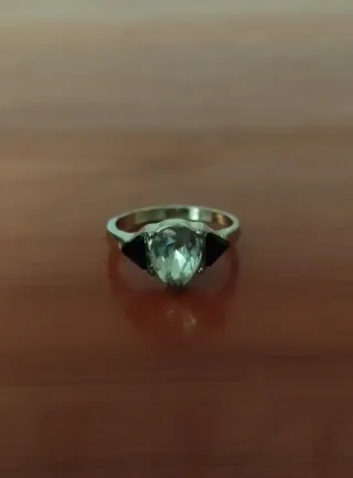 Anillo dorado con piedra transparente y detalles