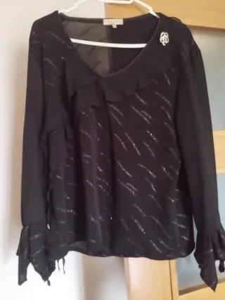 Blusa negra con brillos y volantes y la falda
