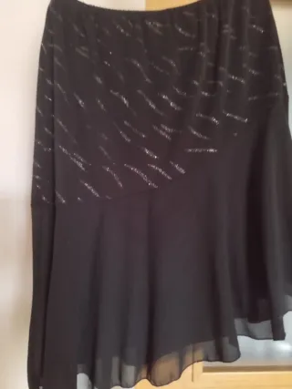 Blusa negra con brillos y volantes y la falda