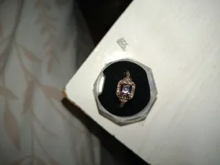 Anillo dorado con piedra morada