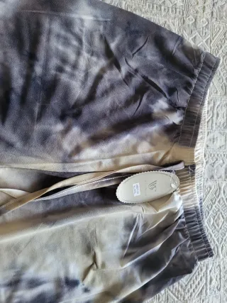 Pantalón tie-dye beige y gris, efecto desteñido.