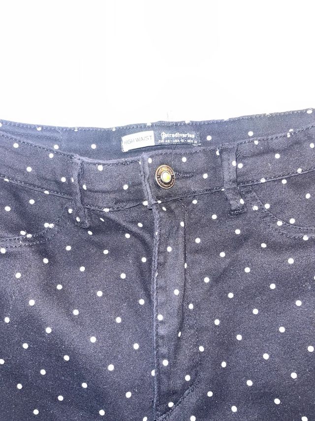 Pantaloni neri con pois bianchi