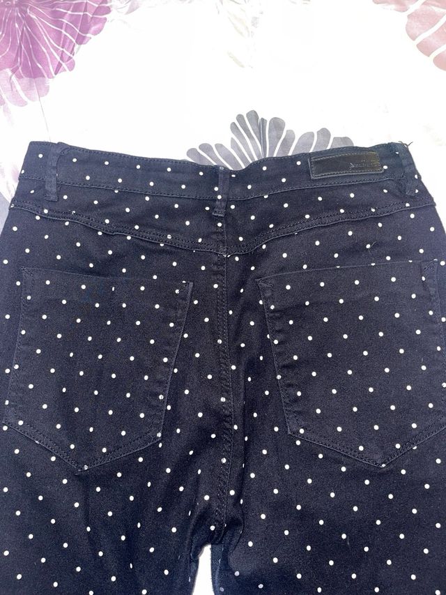 Pantaloni neri con pois bianchi