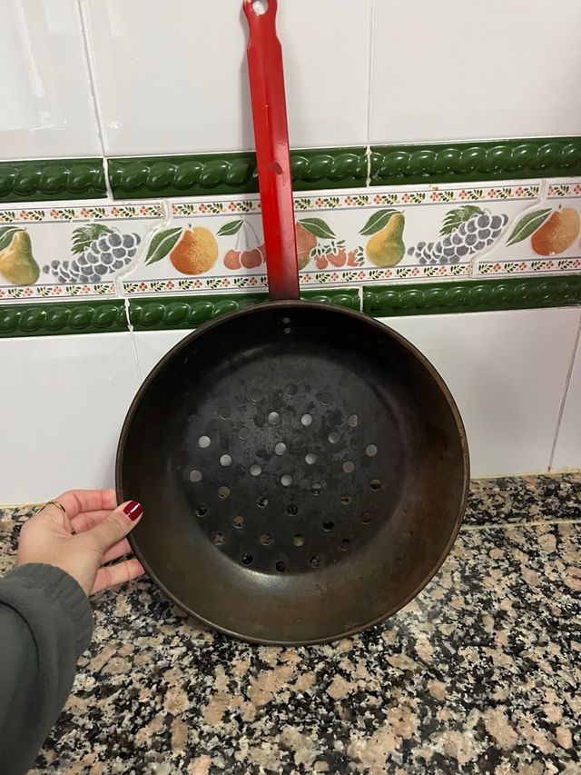 Asador de castañas con mango rojo