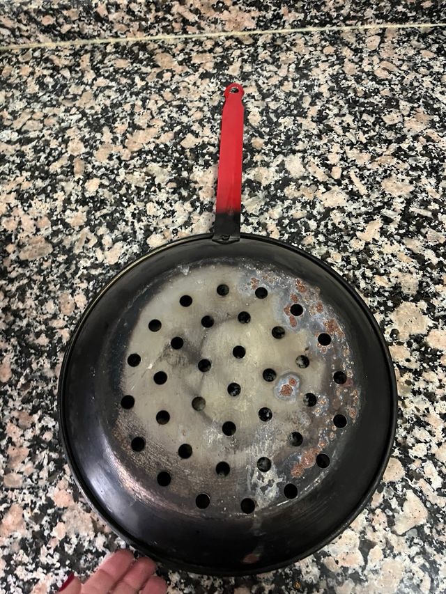 Asador de castañas con mango rojo