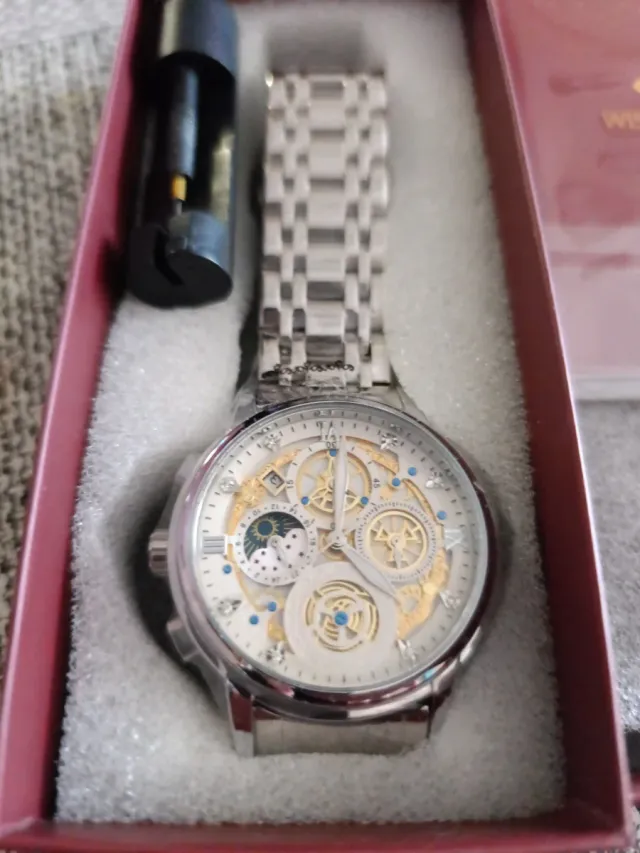 Relógio de pulso prateado com detalhes dourados