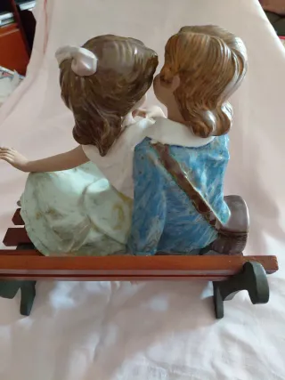 Figura de pareja enamorada en banco