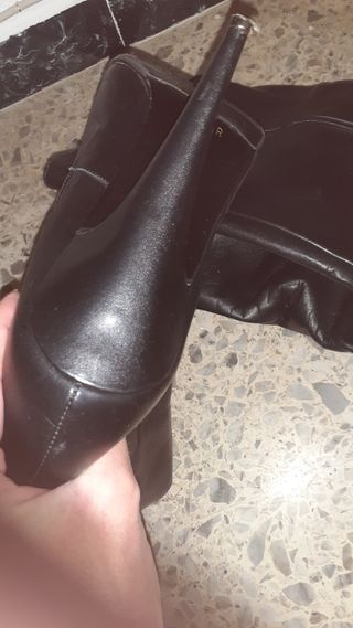 Botas de tacón altas negras y pechos silicona.