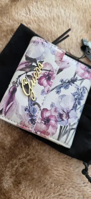 Cartera Guess floral morado y blanco.