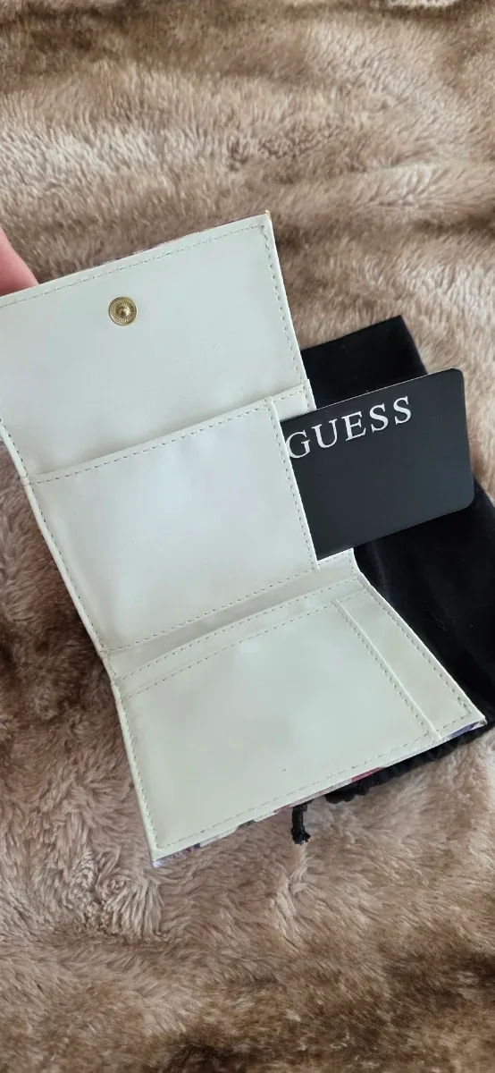 Cartera Guess floral morado y blanco.