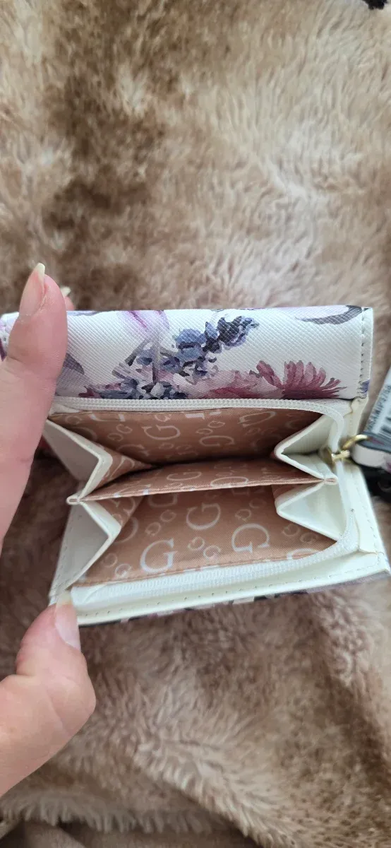 Cartera Guess floral morado y blanco.