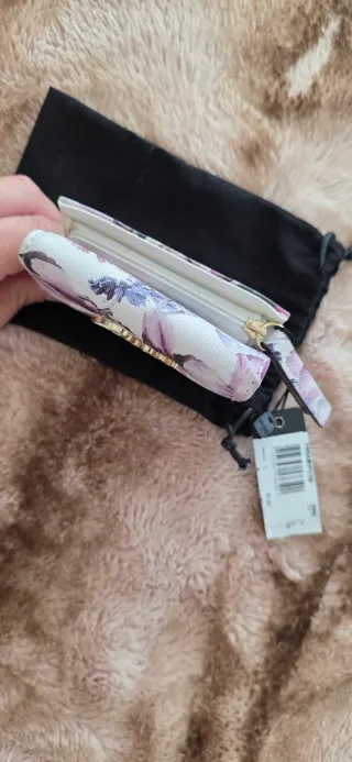 Cartera Guess floral morado y blanco.
