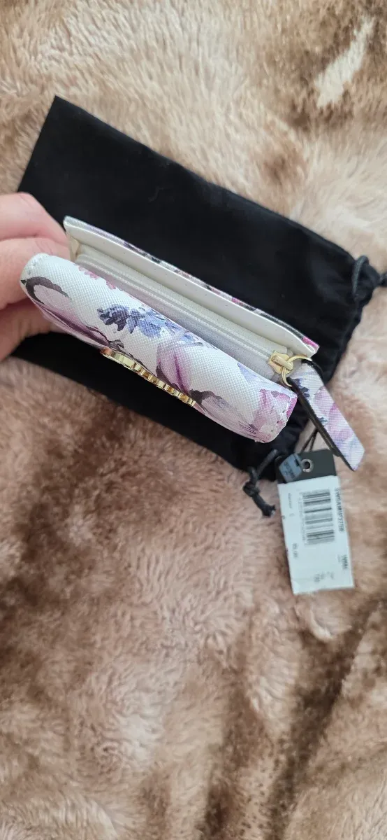 Cartera Guess floral morado y blanco.