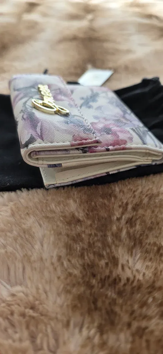 Cartera Guess floral morado y blanco.