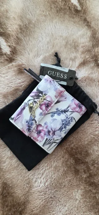 Cartera Guess floral morado y blanco.