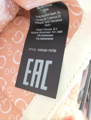 Cartera Guess floral morado y blanco.