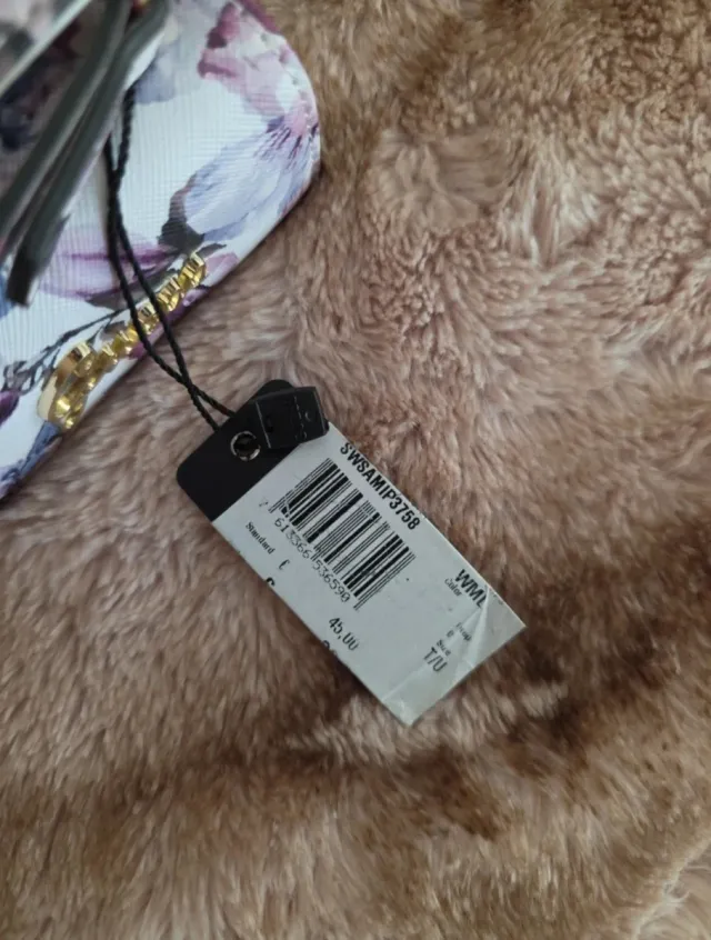 Cartera Guess floral morado y blanco.