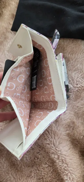 Cartera Guess floral morado y blanco.