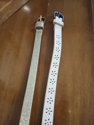 Cinturones finos uno plateado y otro en blanco.