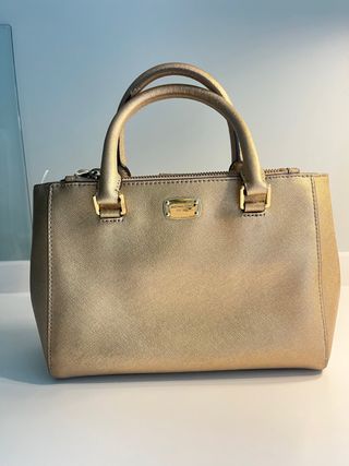Bolso Michael Kors Dorado. Pequeño mano y cruzado.