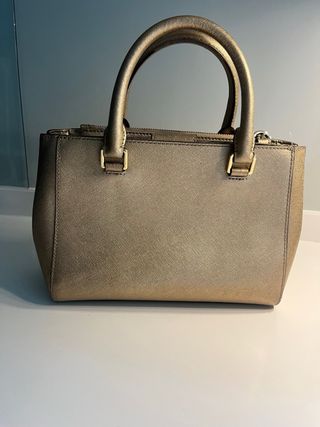 Bolso Michael Kors Dorado. Pequeño mano y cruzado.