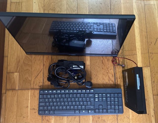 Ordenador negro con teclado, torre y cables.