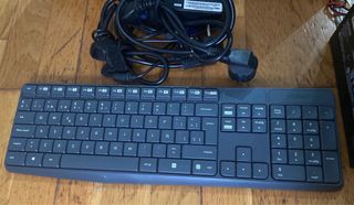 Ordenador negro con teclado, torre y cables.