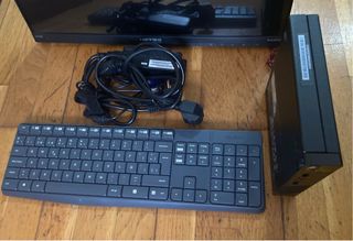 Ordenador negro con teclado, torre y cables.