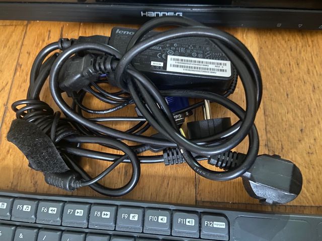 Ordenador negro con teclado, torre y cables.