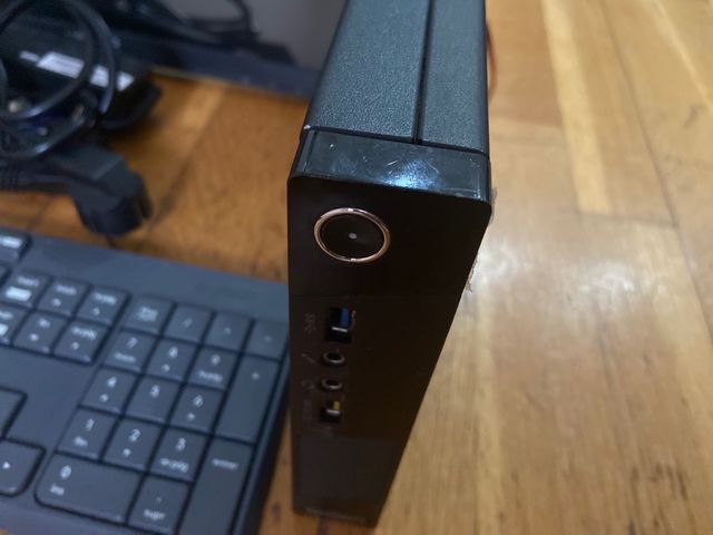 Ordenador negro con teclado, torre y cables.