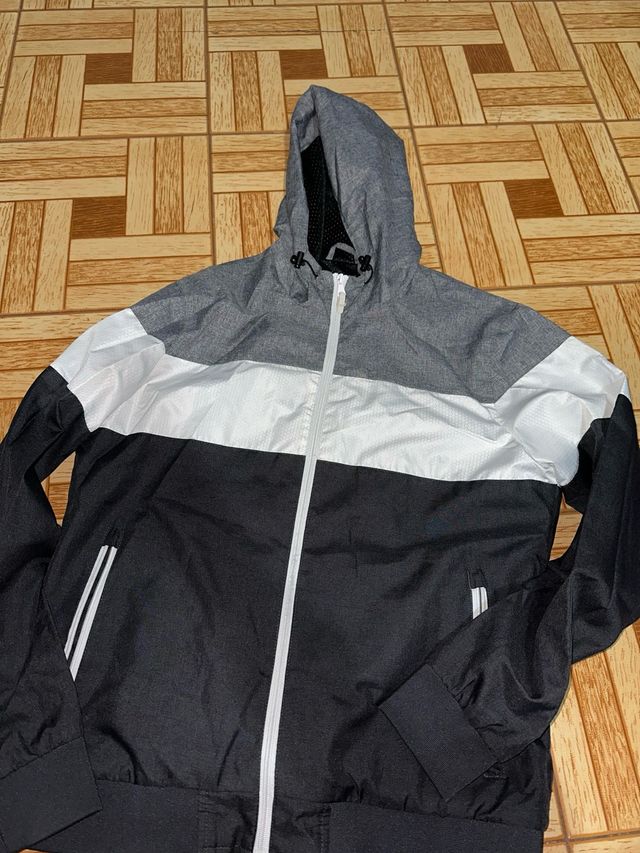 Chaqueta deportiva gris, blanca y negra