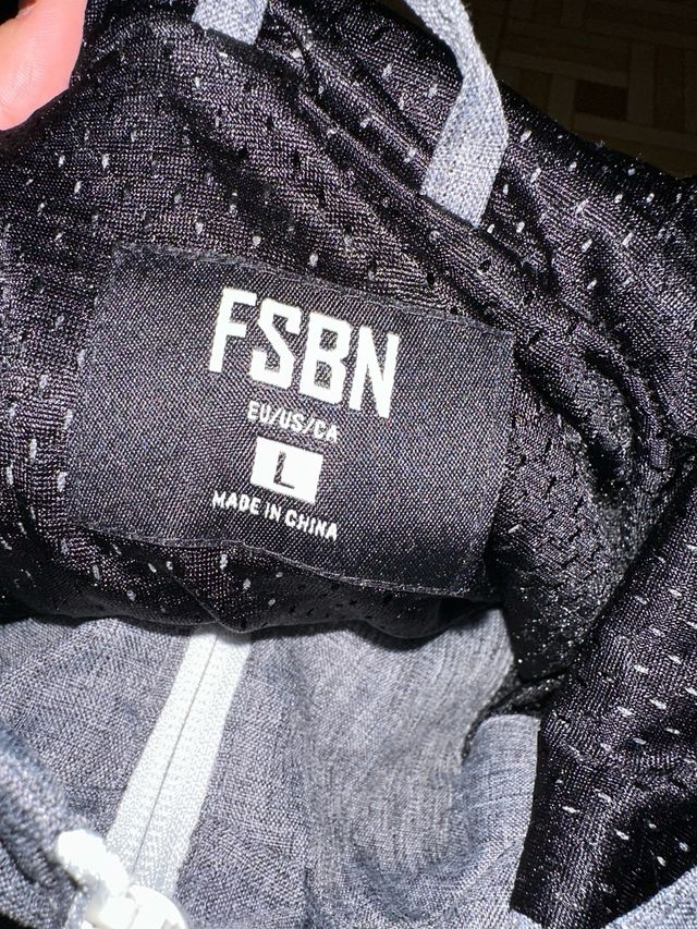 Chaqueta deportiva gris, blanca y negra