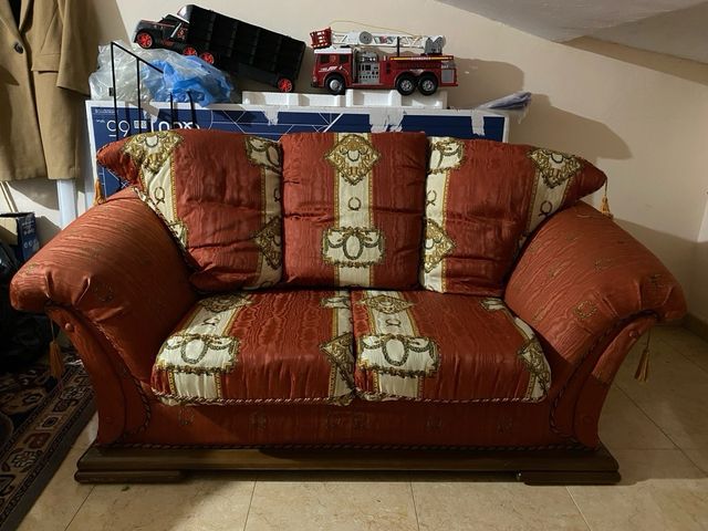 Sofá de tela con detalles dorados. A RECOGER