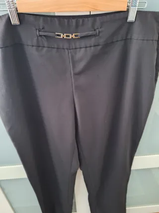 Pantalón negro con detalle plateado.