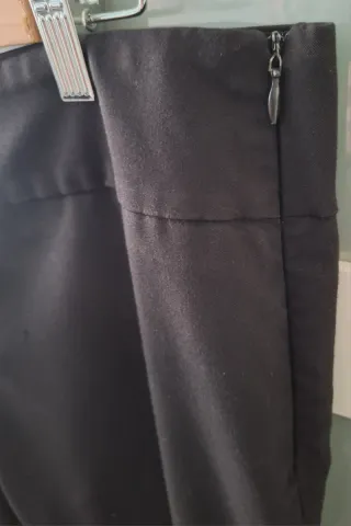 Pantalón negro con detalle plateado.