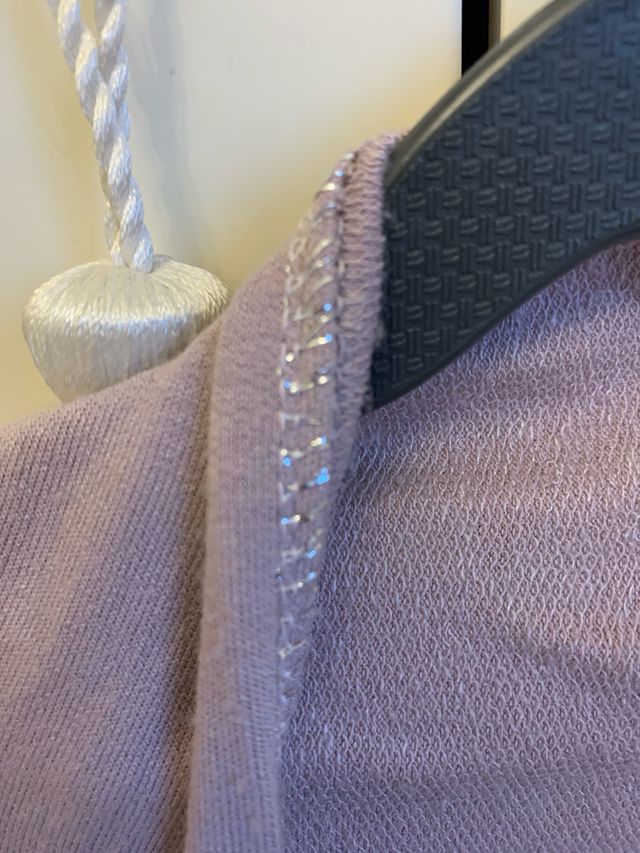 Chaqueta rosa palo con pespunte plateado.