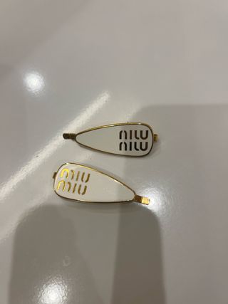 Ganchos Miu Miu dourados e brancos