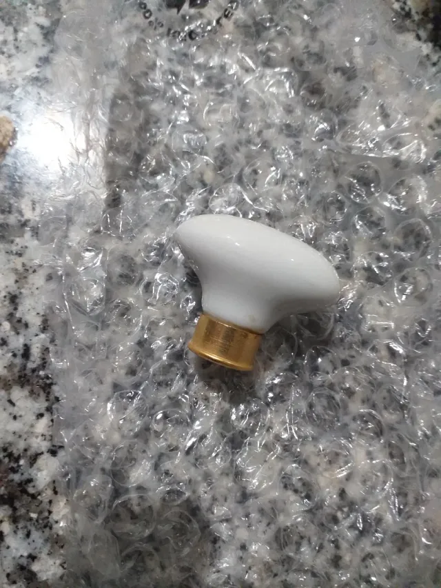 8 Tiradores  blancos de ceramica con base dorada.