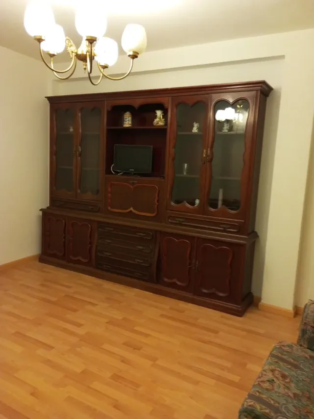 Mueble de salón clásico de madera y cristal.