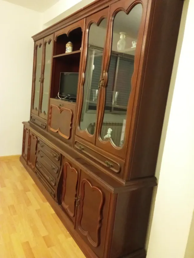 Mueble de salón clásico de madera y cristal.