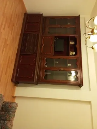 Mueble de salón clásico de madera y cristal.