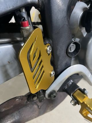 Protector tapa bomba freno Derbi Euro 3 dorado