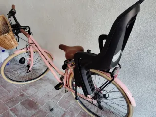 Bicicleta rosa con cesta y silla para niño