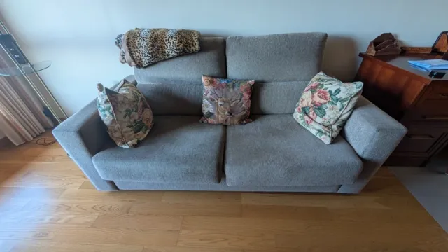 Sofá cama beige con cojines decorativos