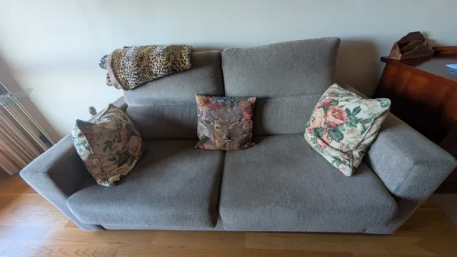 Sofá cama beige con cojines decorativos