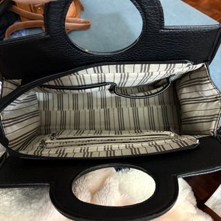 Bolso negro con asa redonda y tachuelas