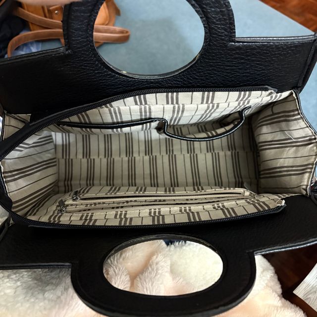 Bolso negro con asa redonda y tachuelas