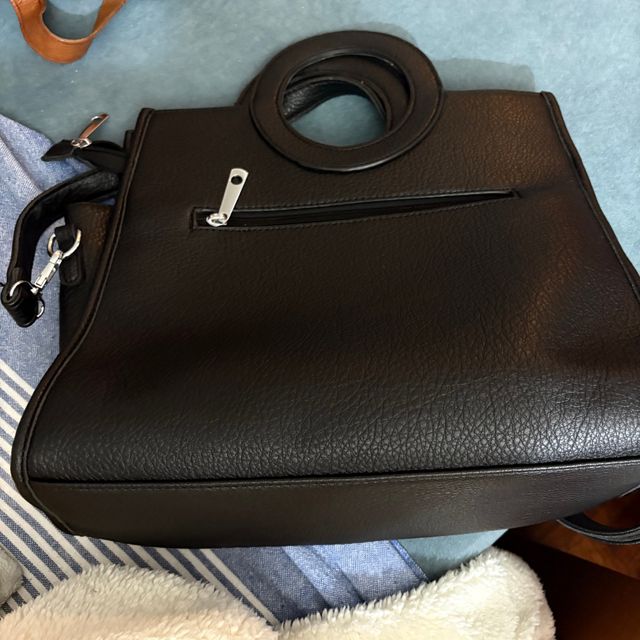 Bolso negro con asa redonda y tachuelas